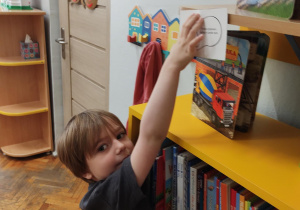Chłopiec przykleja kodeks czytelnika